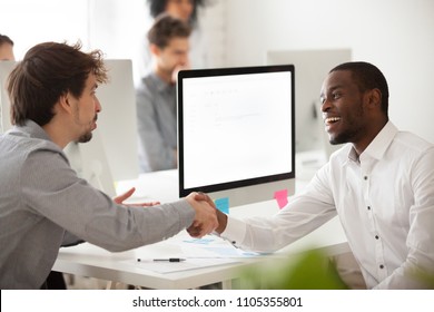 Smiling Worker Shaking Hand Of Caucasian Client, Greeting, Making Good First Impression, Black Employer Congratulating Job Applicant With Successful Interview, Handshaking. Mock Up Computer  Screen