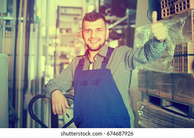 Smiling Worker Shows His Work Place In The Workshop