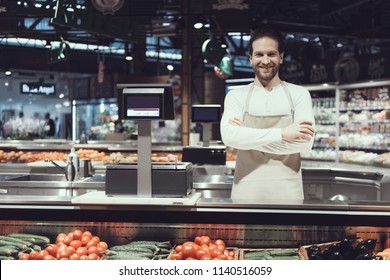 Smiling Worker in Vefatable Department in Supermarket. Bearded Man in Apron. Vegaterian Food. Worker with Weighing-machine. Worker of Supermarket Concept. Healthy Lifestyle. Fresh Food Concept. - Powered by Shutterstock