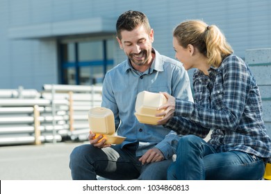 Smiling Workers Outside Factory Having Lunch