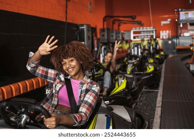 Smiling young adults in go-karts ready for an exciting race at an indoor track. - Powered by Shutterstock