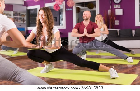 Smiling young adults having group fitness class in sport club