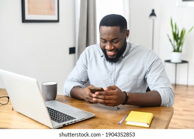 Smiling Young African American Hipster Business Man Professional Making Business, Looking On The Phone, Enjoying Corporate Mobile Conversation Indoors, Freelance Work From Home