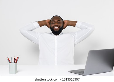 Smiling Young African American Male Business Man In Classic Shirt Posing Work In Office Sitting At Desk With Laptop Pc Sleeping With Hands Behind Head Keeping Eyes Closed Isolated On White Background