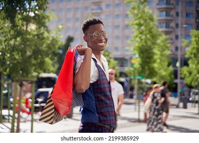 Smiling Young African American Man Carrying Shopping Bags And Looking At Camera