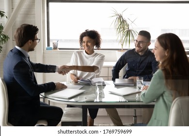 Smiling young african American woman employee shake hand of male boss director at company team meeting in office, multiracial businesspeople colleagues handshake greeting get acquainted at briefing - Shutterstock ID 1769759699