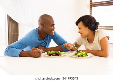 Smiling Young African Couple Eating Dinner Together At Home