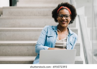 Smiling Young African Female College Student Working On A Laptop On Some Stairs On Campus Preparing For An Exam