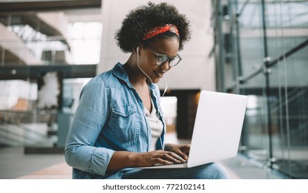 Smiling Young African Female University Student Sitting On A Campus Bench Working On A Laptop While Preparing For An Exam