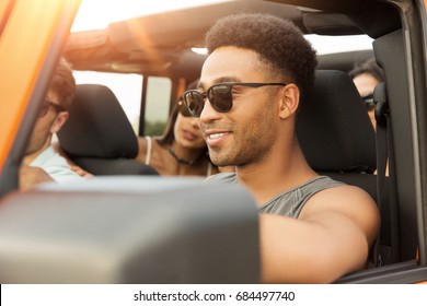 Smiling Young African Man Driving A Car And Having Fun With His Friends