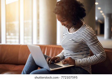 Smiling Young African University Student Studying Online With A Laptop While Sitting On A Sofa On Campus