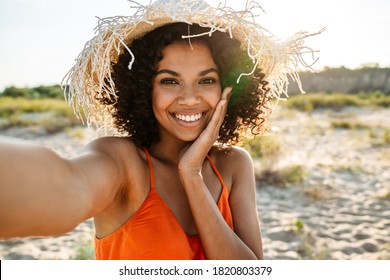 Smiling young african woman taking a selfie at the beach - Shutterstock ID 1820803379