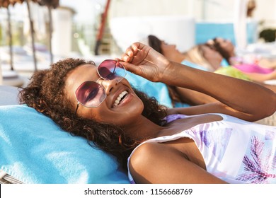 Smiling young afro american woman dressed in swimsuit relaxing at the spa center resort