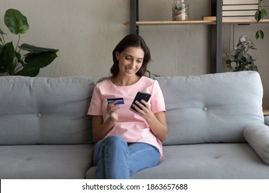 Smiling Young Arabic Indian Woman Holding Bank Credit Card In Hands, Enjoying Shopping Online In Mobile App, Entering Payment Information, Satisfied With Fast Safe Money Transfer, E- Banking Concept.