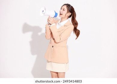 Smiling young Asian business woman leader entrepreneur wearing stylish suit holding megaphone announce on isolated background. - Powered by Shutterstock