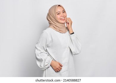 Smiling young Asian Muslim woman feels confident and joyful isolated over white background - Shutterstock ID 2140588827