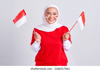 Smiling young Asian muslim woman in red white t-shirt holding flag indonesian to celebrating indonesian independence day on 17 august isolated on white background
