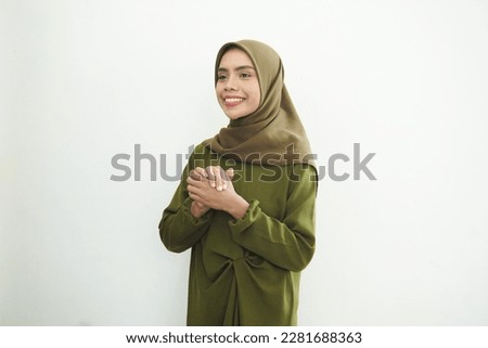 Smiling young Asian Muslim woman feels confident and joyful isolated over white background. Ramadan Concept.