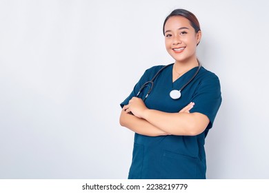 Smiling young Asian woman nurse wearing blue uniform with stethoscope cross arms chest and looking at the camera isolated on white background. Healthcare medicine concept - Powered by Shutterstock