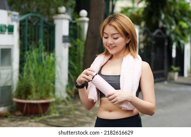 Smiling Young Asian Woman Opening Bottle Of Electrolyte Water To Drinking After Morning Jog