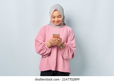 Smiling Young Asian Woman In Pink Shirt Using Mobile Phone And Received Good News Isolated Over White Background