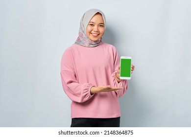 Smiling Young Asian Woman In Pink Shirt Showing Mobile Phone Blank Screen Recommending App Isolated Over White Background