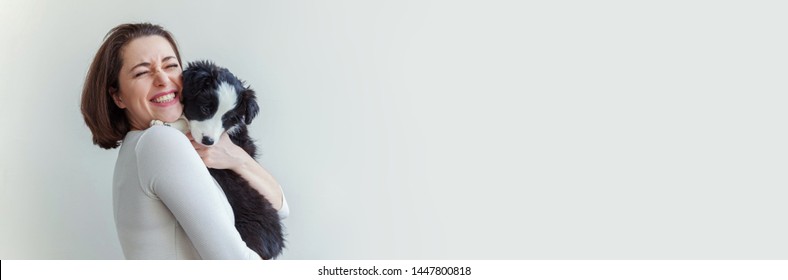 Smiling Young Attractive Woman Embracing Cute Puppy Dog Border Collie Isolated On White Background. Girl Huging New Lovely Member Of Family. Pet Care And Animals Concept. Banner
