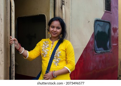 Smiling Young Backpacker Indian Woman Standing On Wagon At Train Station. Travel Concept