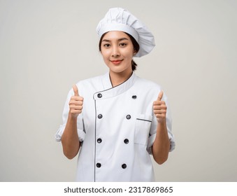 Smiling Young beautiful asian woman chef in uniform showing thumbs up on isolated background. Cooking woman Occupation chef or baker People in kitchen restaurant and hotel. - Powered by Shutterstock