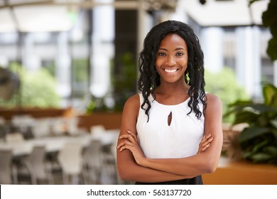 Smiling young black businesswoman with arms crossed