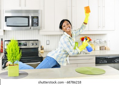 Smiling Young Black Woman Dancing And Enjoying Cleaning Kitchen