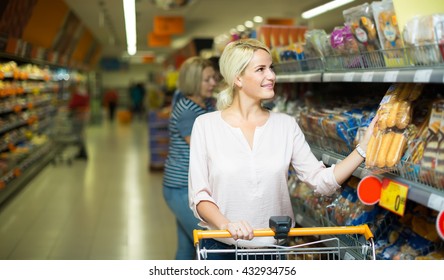 Smiling young blonde woman buying bread and pastry in food shop
 - Powered by Shutterstock