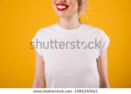 Smiling young blonde woman in white T-shirt. Template. Yellow background