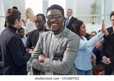 smiling young business man standing among his colleagues. - Shutterstock ID 1913687452