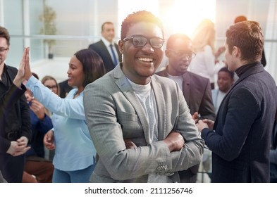 Smiling Young Business Man Standing Among His Colleagues.