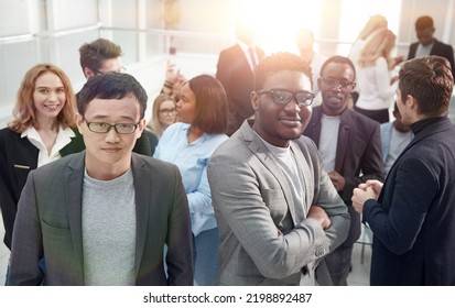 Smiling Young Business Man Standing Among His Colleagues.