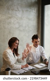 Smiling Young Business People Waving With Hands When Video Calling Coworker To Discuss Project