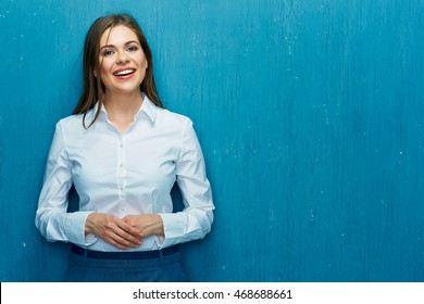 Smiling Young Business Woman Portrait On Blue Wall Background. White Shirt.