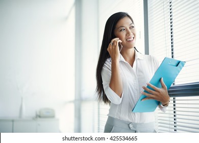 Smiling young business woman talking on phone