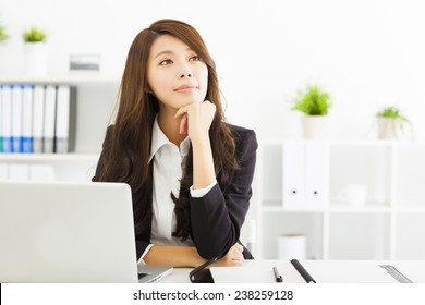 Smiling Young Business Woman Thinking In The Office