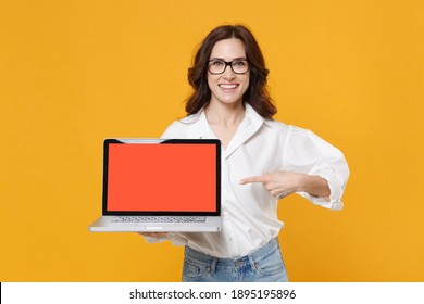 Smiling Young Business Woman In White Shirt Glasses Isolated On Yellow Background Studio. Achievement Career Wealth Business Concept. Point Index Finger On Laptop Pc Computer With Blank Empty Screen