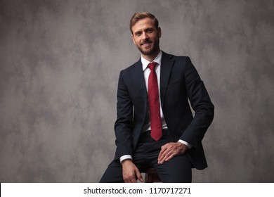 Smiling Young Businessman Sitting On A Stool , Studio Picture