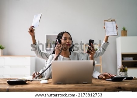 Smiling Young Businesswoman Doing Multitasking Work At Workplace