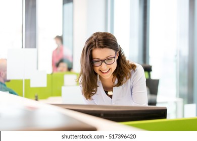 Smiling young businesswoman using computer in office