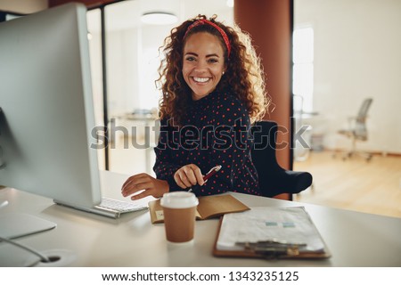 Foto Bild Geschäftsfrau, die an ihrem Laptob arbeitet, sitzt auf einer Couch.