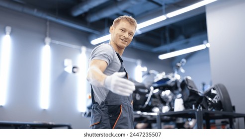 Smiling young car mechanic stands in workshop. Car and motorcycle maintenance services concept - Powered by Shutterstock