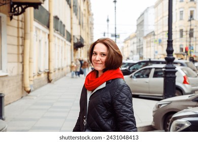 smiling young Caucasian female woman looking at camera on street of european city. positive emotion, tourism, date, love, valentine's day concept. lifestyle waist up portrait of 38 years old woman