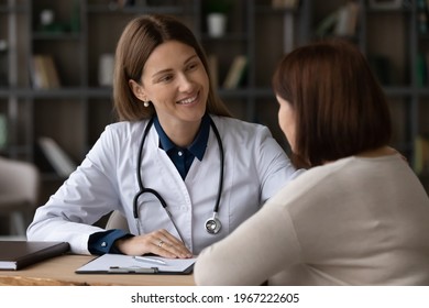 Smiling Young Caucasian Woman Doctor Support Elderly Patient At Meeting In Hospital. Happy Female Nurse Or GP Talk Consult With Mature Client At Clinic Consultation. Healthcare, Geriatrics Concept.