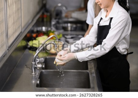 Smiling young chefs learning kitchen hygiene and teamwork in a professional cooking school