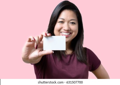 Smiling Young Chinese Woman Holding Up A Blank White Business Card On Display In A Concept Of Identification, Qualifications, Contact Or Branding, Focus On Card